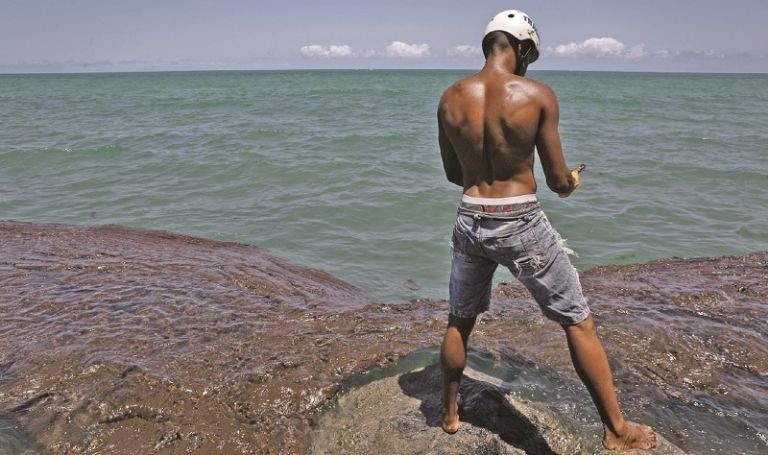 Un voluntario saca  el crudo derramado en la playa de Janga, estado de Pernambuco.